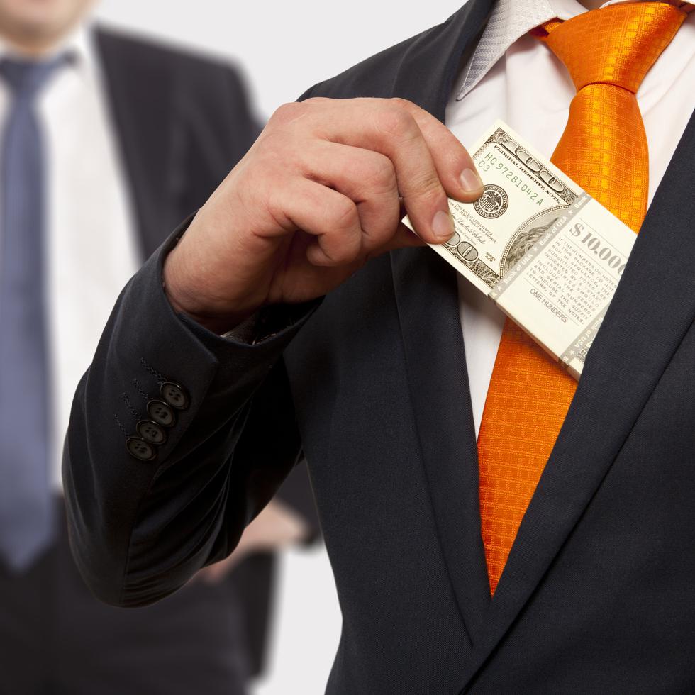 Businessman putting money in suit jacket pocket, concept for corruption, bribing