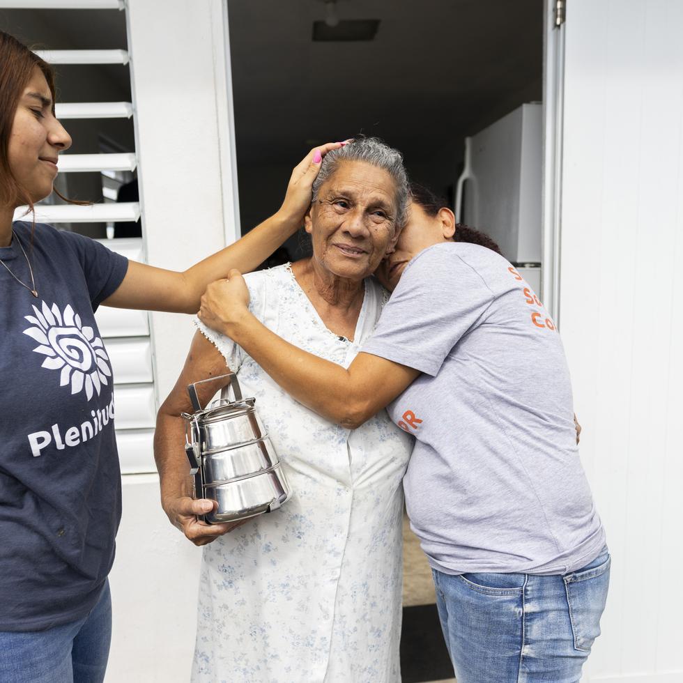 Como parte de la ruta de entrega de alimentos, Natalia Jiménez y su mamá, Migdalia Mass Llorens, llegaron hasta el hogar de Miriam González Lamberty, de 73 años (centro).