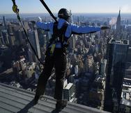 Una persona disfruta de las vistas de Nueva York desde la plataforma más alta de edificio 30 Hudson Yards, sostenido por sogas.