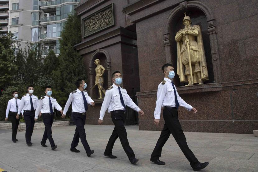 Guardias de seguridad caminan por Pekín. (AP)
