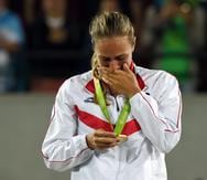 Mónica Puig mira con emoción su medalla de oro.