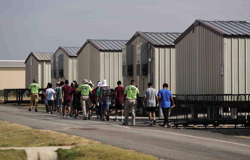 Empleados escoltando a jóvenes a clases en el centro de detención más nuevo del gobierno de Estados Unidos para menores migrantes en Carrizo Springs, Texas. (AP/Eric Gay)