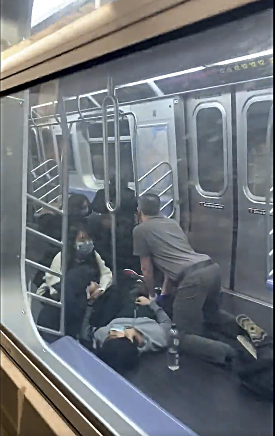 En esta foto facilitada por Will B Wylde, una persona es auxiliada en un vagón de metro en el barrio neoyorquino de Brooklyn, el martes 12 de abril de 2022. 