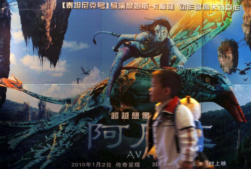 Un niño chino camina junto a un poster de la película Avatar a la entrada de un cine en Guangzhou, en China.