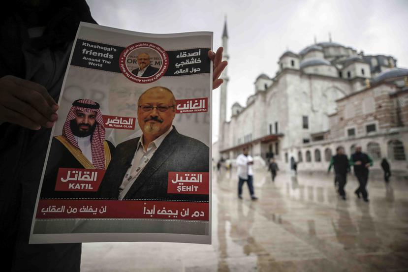 Un hombre sostiene un cartel que muestra imágenes del príncipe heredero saudí Muhammed bin Salman y del periodista Jamal Khashoggi, en el que se describe al príncipe como "asesino" y a Khashoggi como "mártir". (AP)