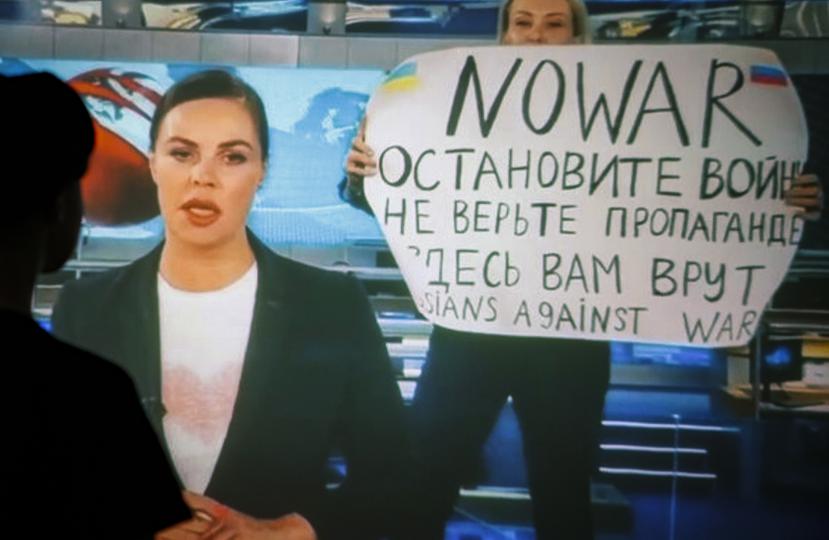 Una mujer ve una transmisión grabada del programa de televisión de noticias del canal ruso Channel One en el que un empleado entró en el estudio con un cartel que se podía leer "No a la guerra". Detengan la guerra. No creas en la propaganda. Aquí te están mintiendo" en Moscú.