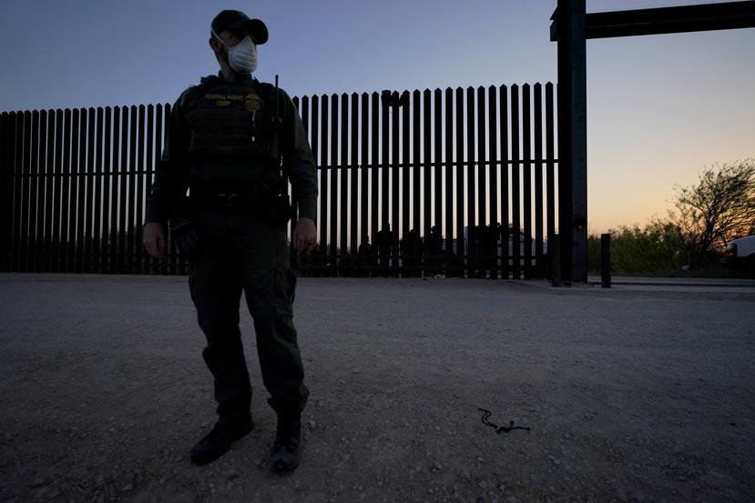 Un agente de la Oficina de Aduanas y Protección Fronteriza monta guardia cerca de una puerta en el muro en la frontera entre México y Estados Unidos durante un operativo de detención de migrantes, en Abram-Perezville, Texas.