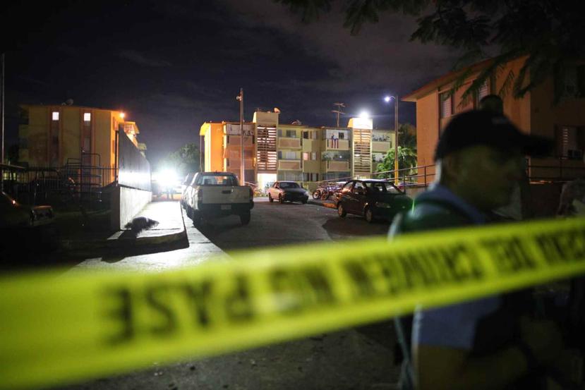 Agentes de la Policía analizan la escena de la balacera que cobró la vida de cinco personas en el residencial Ernesto Ramos Antonini.