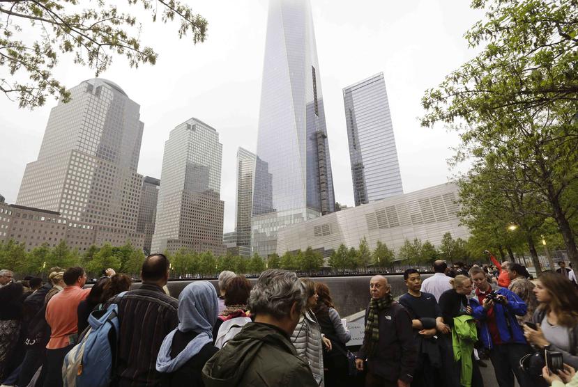 Un grupo de gente cerca de los monumentos conmemorativos del Memorial del 11 de septiembre en Nueva York. (AP)