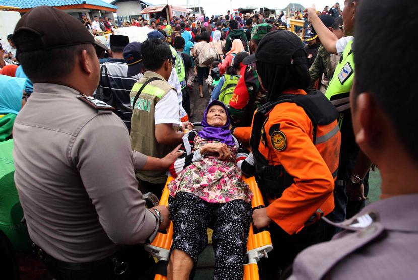 Una mujer es desalojada de la isla de Sebesi por miembros del equipo de rescate tras el tsunami que azotó Sunda Strait, en el puerto de Bakauheni, Indonesia. (EFE)