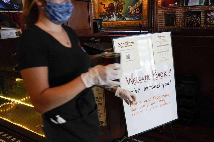 Un letrero da la bienvenida a clientes en la San Pedro Brewing Company en Los Angeles. (AP)