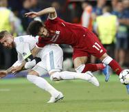 En esta foto del 26 de mayo del 2018, el zaguero de Real Madrid Sergio Ramos, izquierda, le comete una falta al delantero de Liverpool Mohammed Salah en la final de la Liga de Campeones en el Olimpiyskiy Stadium en Kiev, Ucrania. (AP)