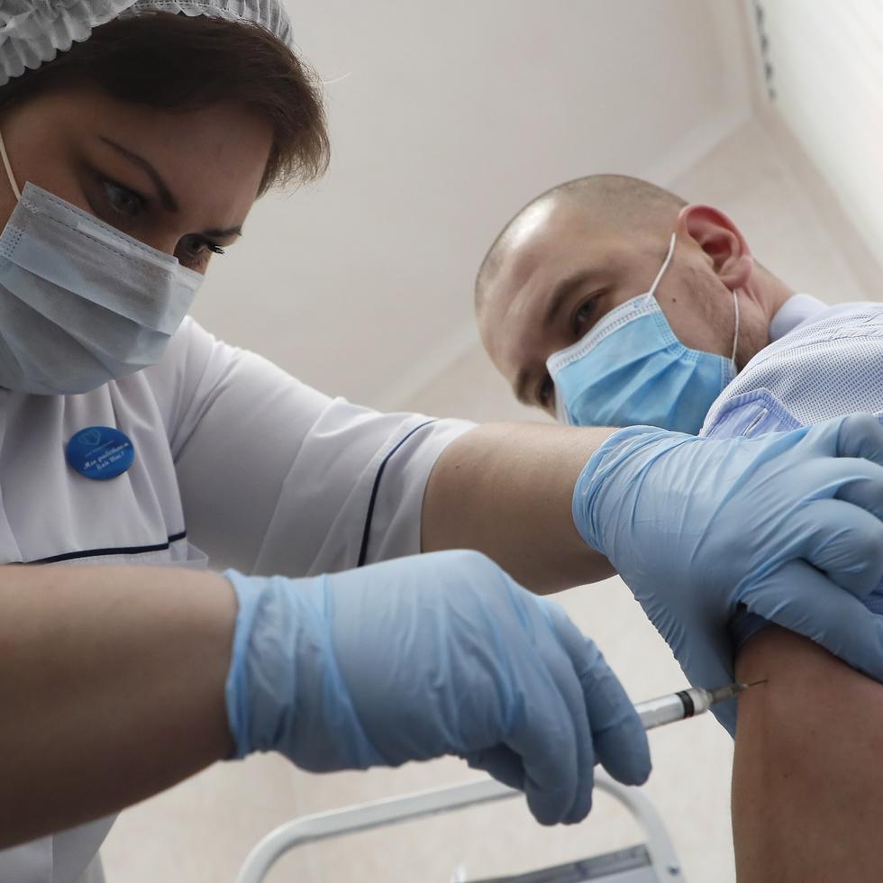 Una profesional de la salud en Rusia coloca a un ciudadano la vacuna contra el COVID-19.