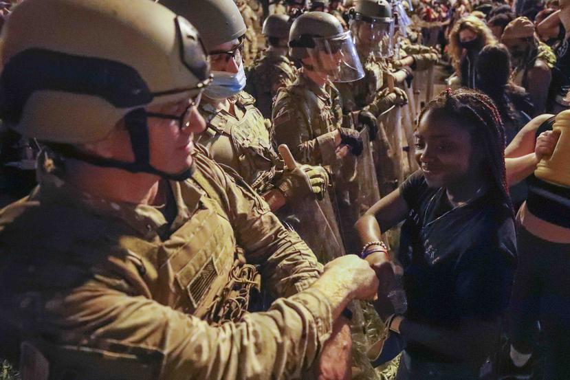 Un miembro de la Guardia Nacional de Utah saluda a una joven durante una protesta. (AP / Alex Brandon)