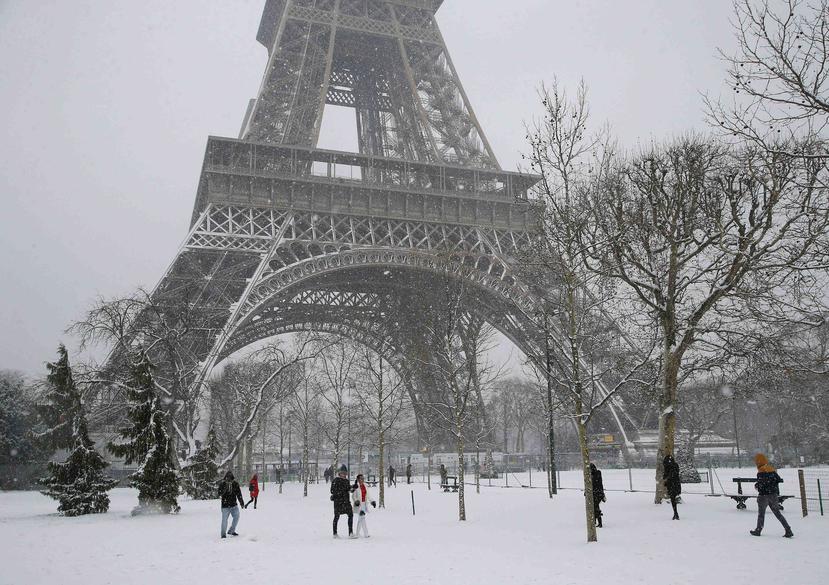 Gente camina por la nieve frente a la Torre Eiffel en París, Francia, el viernes 9 de febrero de 2018. (AP)