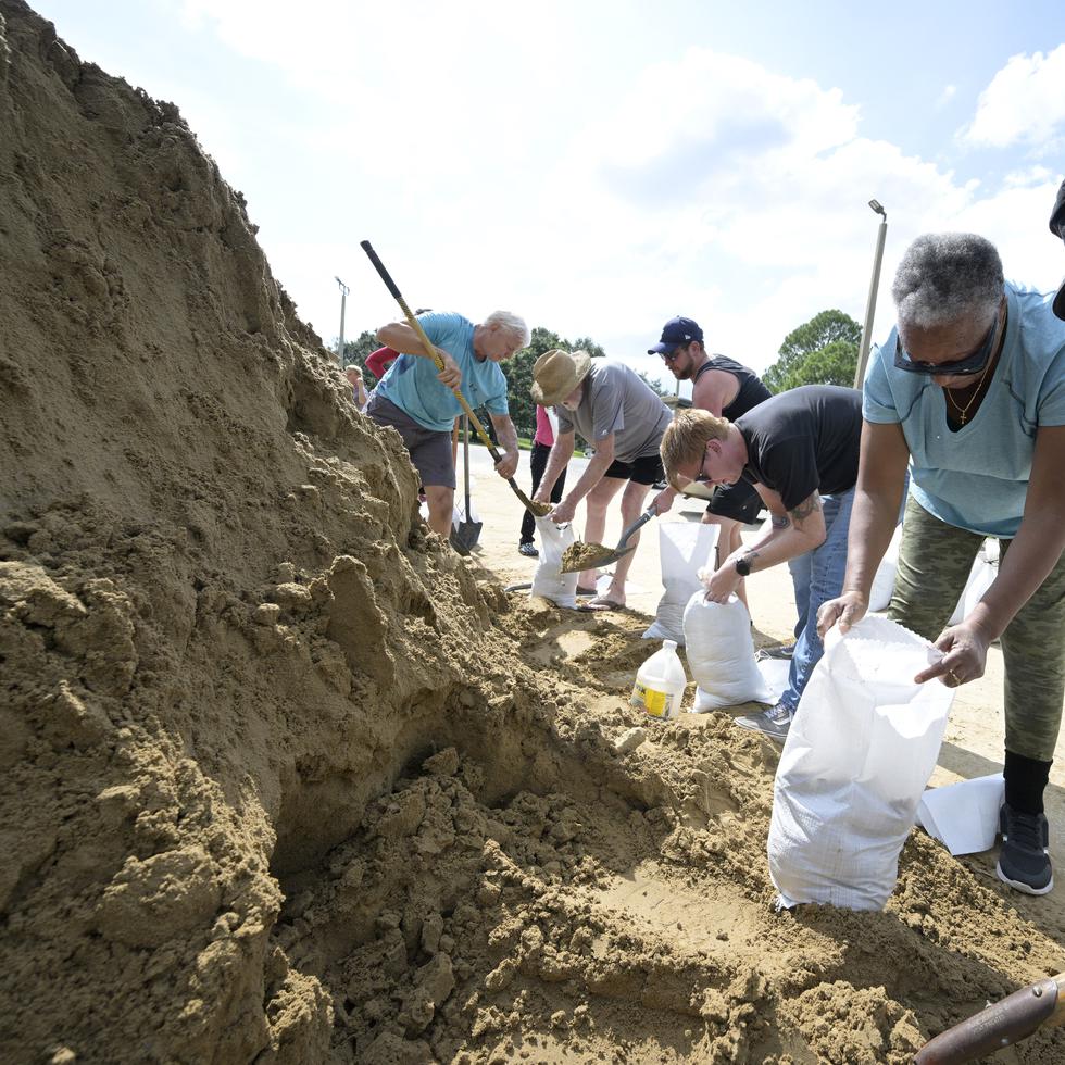 Johnny Ford, right, and his wife Jerria Ford fill free sand bags at an Orange County park in preparation for the arrival of Hurricane Ian, Monday, Sept. 26, 2022, in Orlando, Fla. (AP Photo/Phelan M. Ebenhack)
