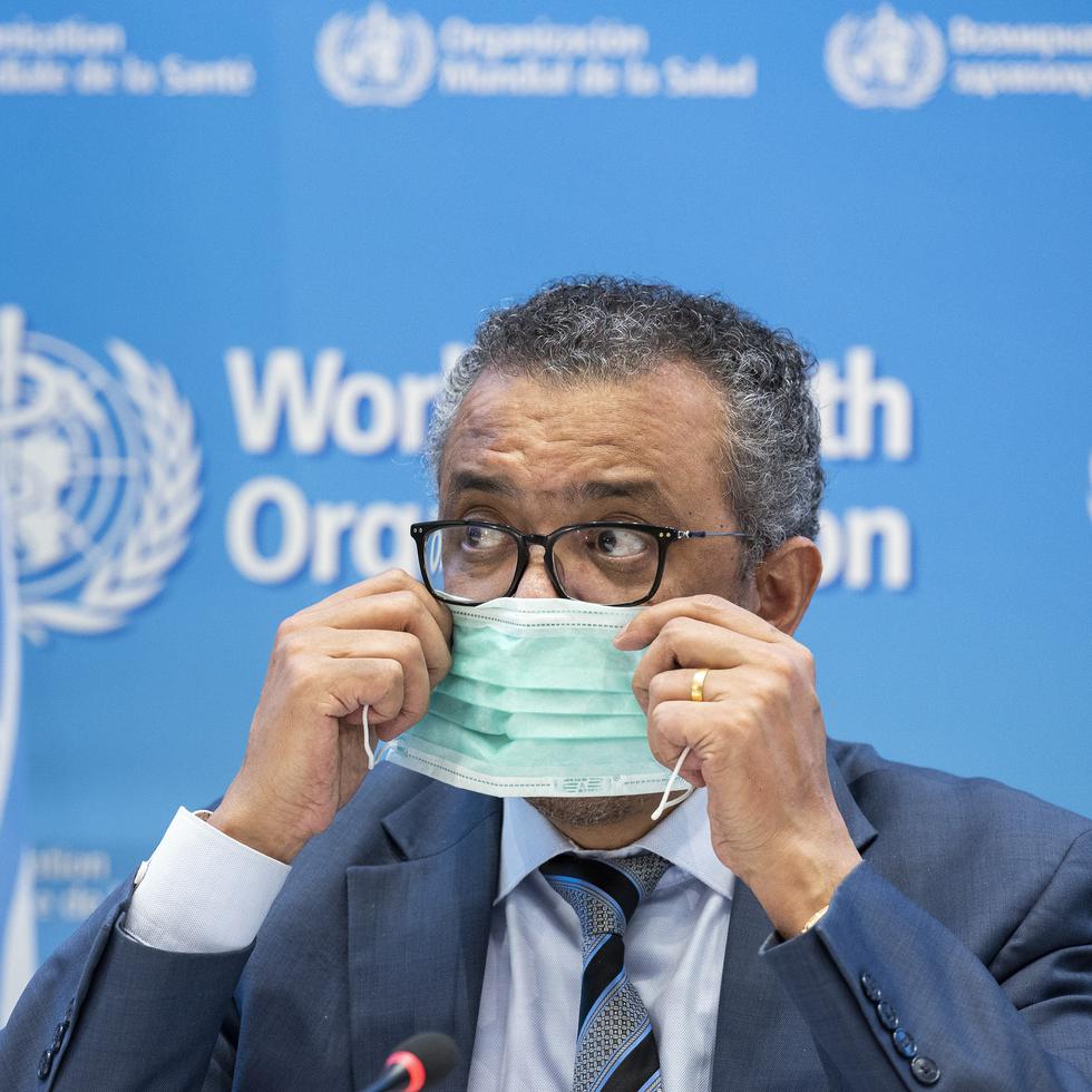 Tedros Adhanom Ghebreyesus, director general de la OMS, se apresta a retirarse la mascarilla antes de hablar a los medios de comunicación sobre la pandemia de COVID-19 y las prioridades de la organización en 2022, durante una conferencia de prensa en Ginebra, Suiza.