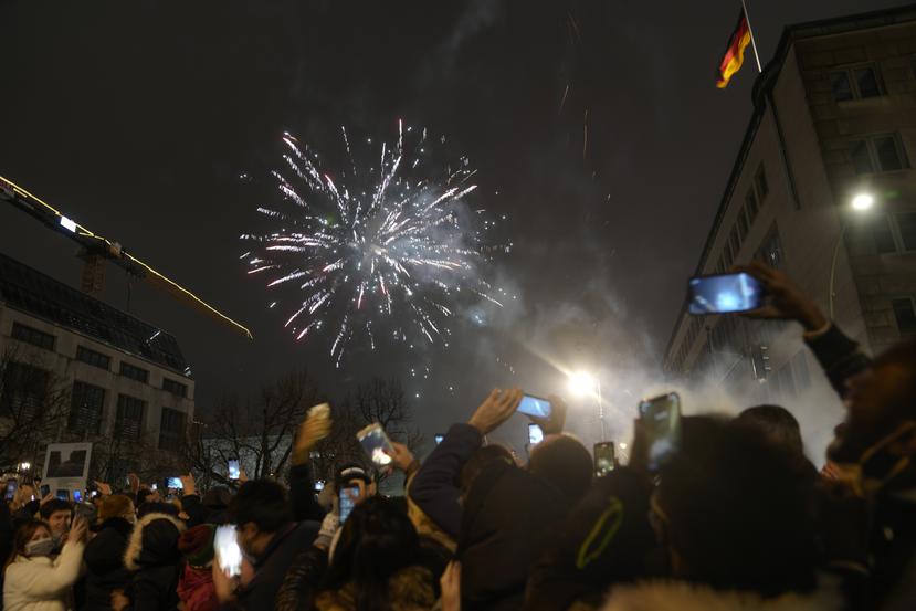 Una multitud en el boulevard Unter den Linden disfruta los fuegos artificiales por el Año Nuevo cerca de la Puerta de Brandenburgo, el 1 de enero del 2022, en Berlín.