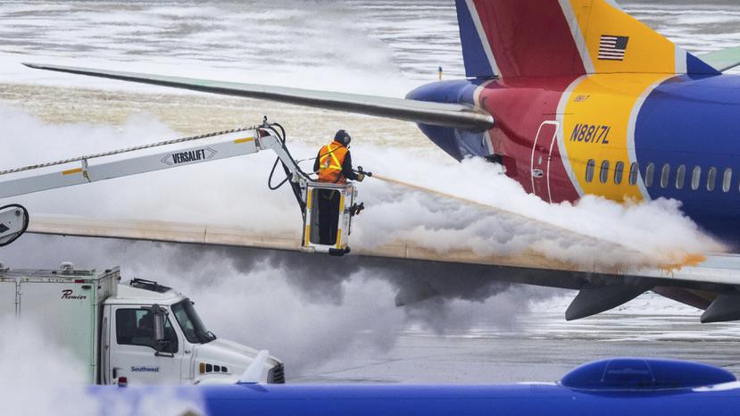 Personal descongela un avión de Southwest Airlines antes del despegue el miércoles 21 de diciembre de 2022 en Omaha, Nebraska. (Chris Machian/Omaha World-Herald vía AP)