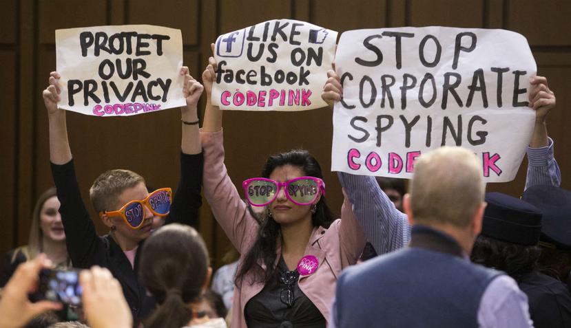 Varias personas mostraban carteles como forma de protesta, mientras el CEO de Facebook, Mark Zuckerberg testificaba en el Senado. (EFE)