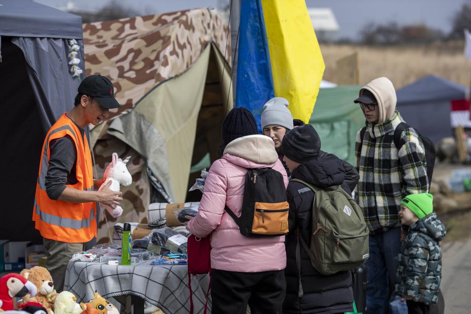 Voluntarios reparten suministros y hasta juguetes a los miles de refugiados que cruzan la frontera de Polonia a diario.