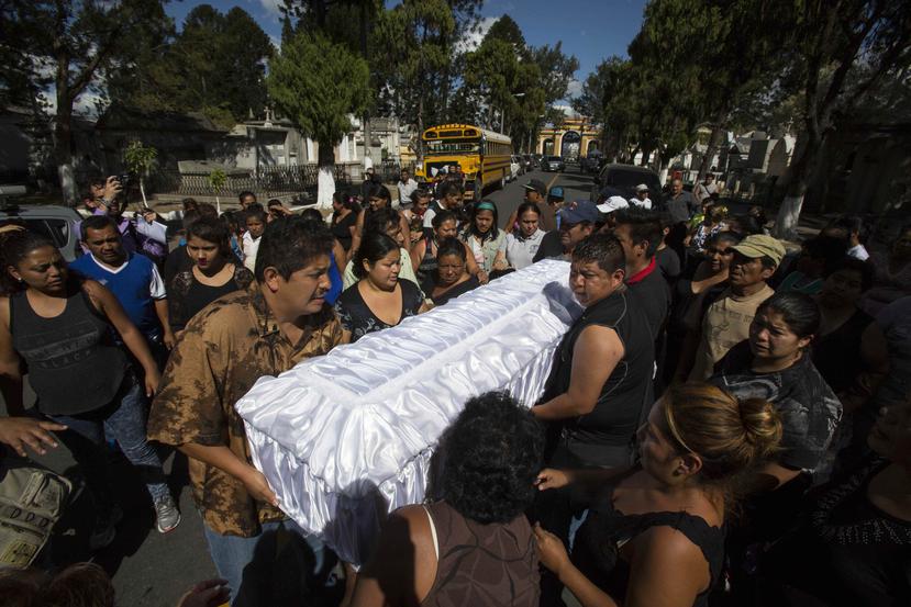 En la foto, varias personas cargan el ataúd de Madelyn Patricia Hernández Hernández, de 14 años que murió en el incendio. (AP)