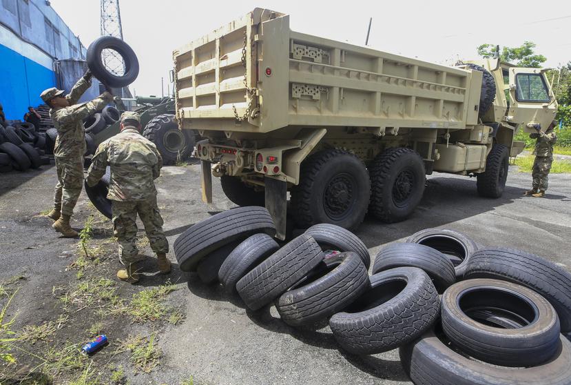 Oficiales de la Guardia Nacional depositan gomas de la gomera "El Árabe" en un camión.
