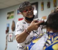 Utuado, P.R. - Letty Martínez Afanador with a client at her barbershop.