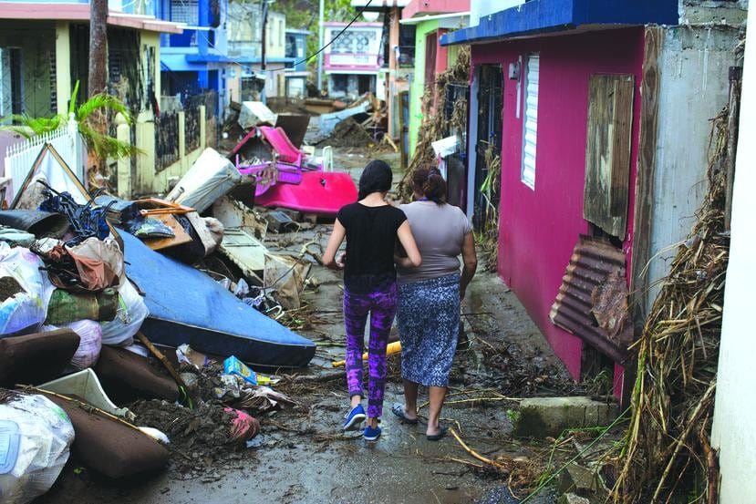 Algunas comunidades sufrieron el impacto del huracán María de manera particular. En esta foto de octubre de 2017, dos mujeres caminan entre los escombros en el sector Chichamba de Yauco.