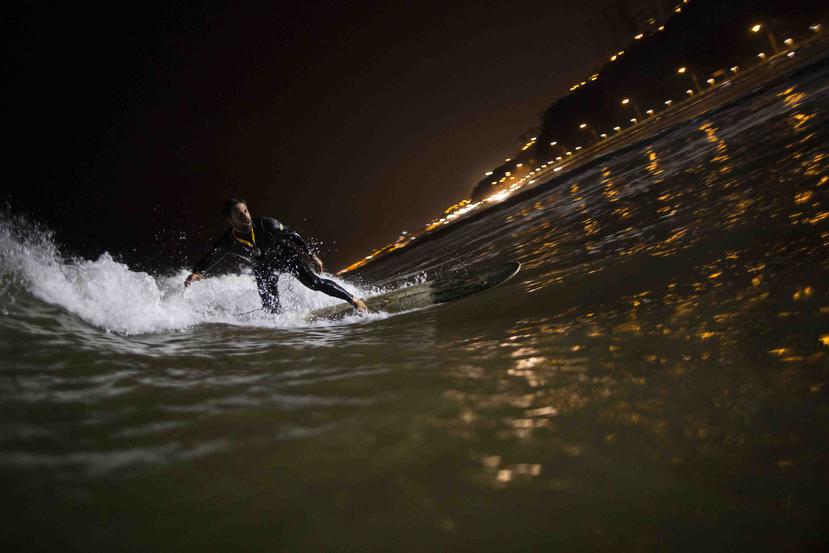 Ernesto Benavides monta una ola en las aguas de la playa de La Pampilla en Lima, Perú. (AP)