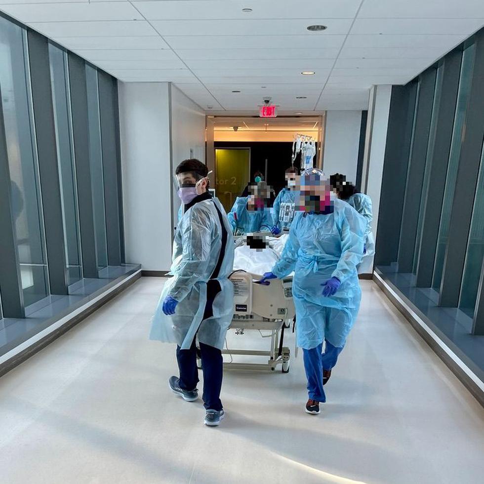 Enfermeros y personal del University Medical Center de New Orleans transportan en camilla a un paciente de COVID.