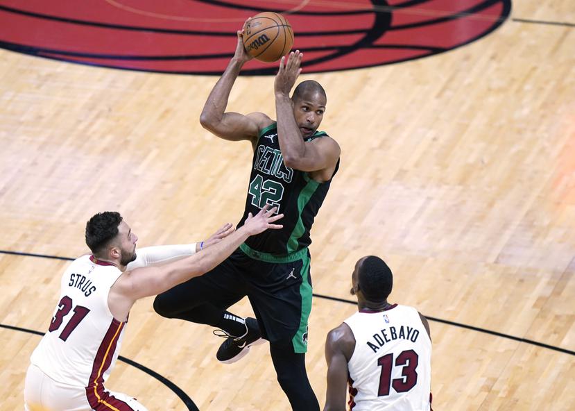 El dominicano Al Horford, de los Celtics, busca pasar el balón ante la defensa del Heat.