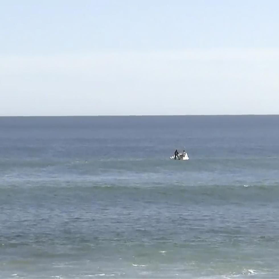 En esta imagen tomada de un video, equipos de búsqueda en botes trabajan en el mar en Elliston, Australia, el sábado 13 de mayo de 2023. La policía seguía buscando el lunes los restos de un surfista de 46 años atacado por un tiburón dos días antes ante la costa de Australia. (Australian Broadcasting Corp. via AP)