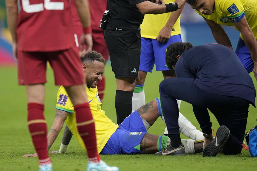 El delantero brasileño Neymar recibe tratamiento durante el partido contra Serbia por el Grupo G del Mundial.