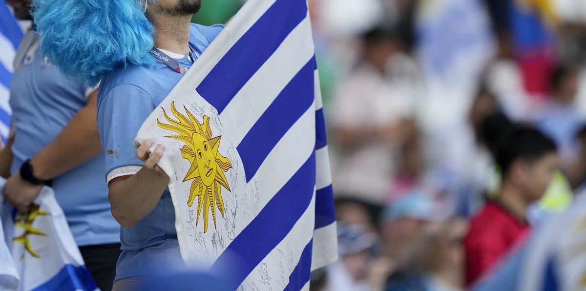 Un fanático del fútbol con la bandera de Uruguay antes del partido contra Corea del Sur en Al Rayyan, Catar.