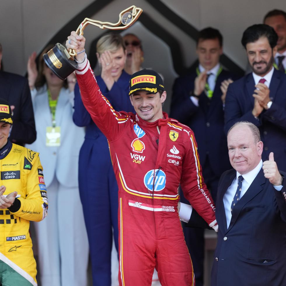 Charles Leclerc, al centro, levanta su trofeo que lo certifica como ganador del GP de Mónaco.