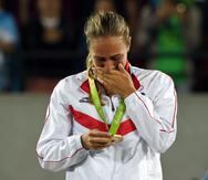 Mónica Puig mira emocionada la medalla de oro que ganó en la final del torneo de sencillos de los Juegos Olímpicos de Río 2016 al vencer a Angelique Kerber.