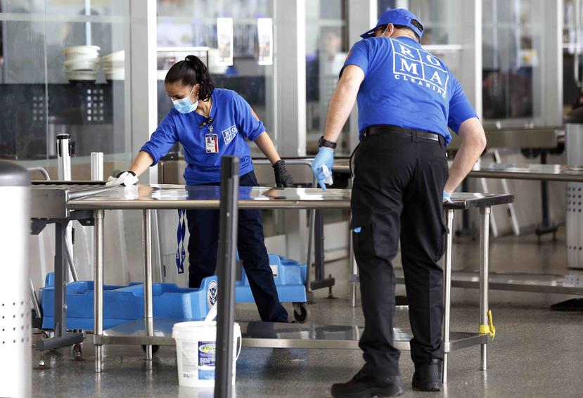 Empleados desinfectan las instalaciones del checkpoint en el terminal 5 del aeropuerto JFK. (AP)