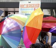 Foto de archivo muestra a un manifestante anti-gay que lleva un cartel que está rodeado por paraguas del Orgullo durante el desfile del Orgullo en Winston-Salem, Carolina del Norte.