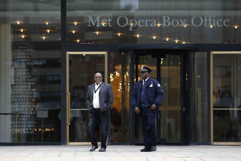 Dos guardias del Lincoln Center caminan frente a la taquilla de la Ópera Metropolitana. (AP)