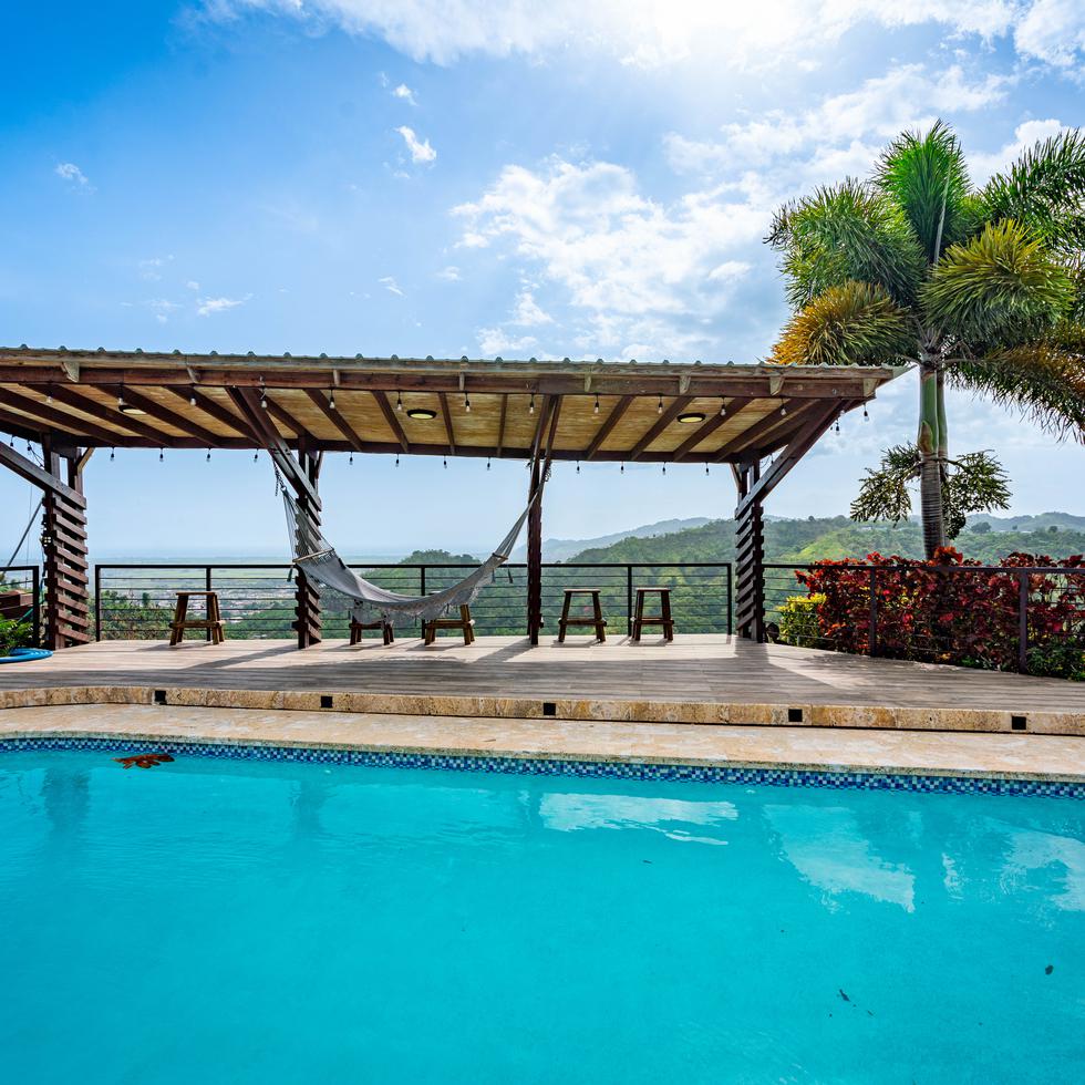 La piscina cuenta con un espacio techado con hamaca para que los huéspedes disfruten al aire libre del sol y la vista.