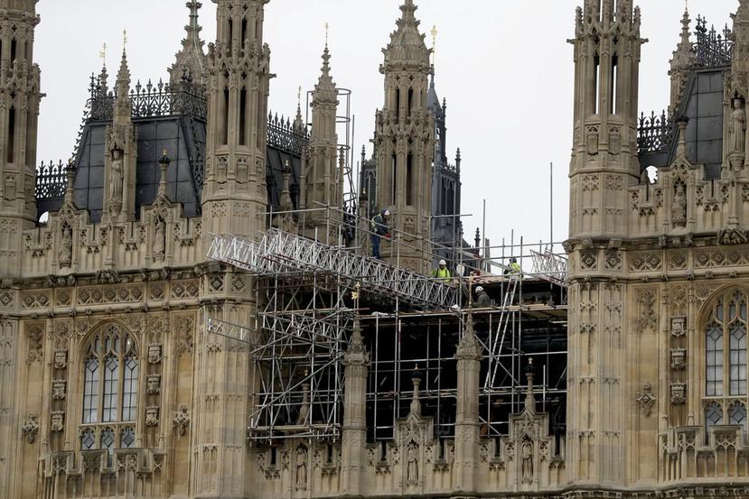 Los trabajadores se paran en andamios para realizar las reparaciones del edificio del Parlamento británico, en Londres (AP / Matt Dunham).