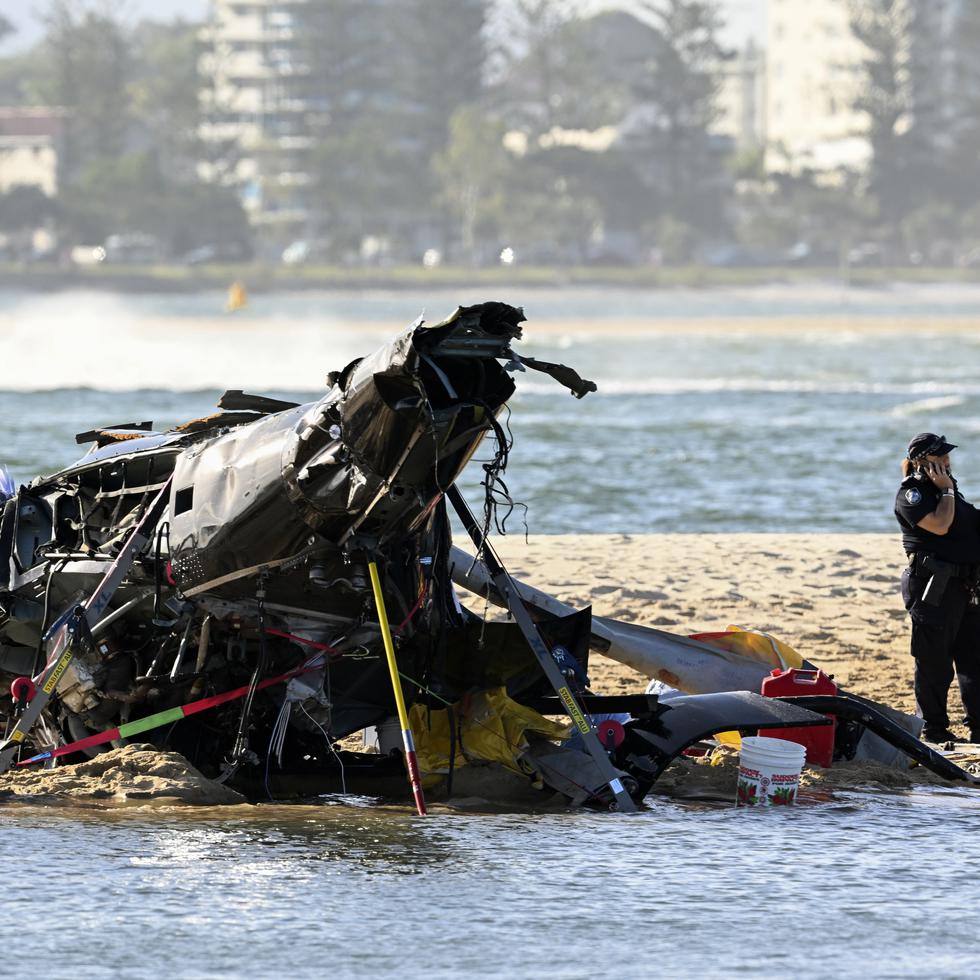 Trabajadores de emergencias revisan un helicóptero en el sitio de un accidente cerca de Seaworld, en Gold Coast, Australia, el lunes 2 de enero de 2023.
