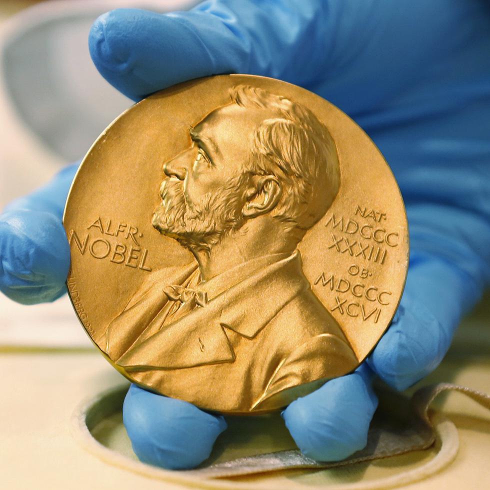 En esta imagen de archivo, un empleado de la biblioteca nacional muestra una medalla de oro del Premio Nobel.