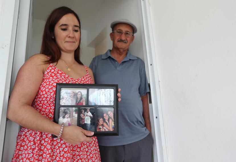 Linnette Díaz, hija de  doña Ana Ida Berríos Torres, muestra un marco con fotografías familiares. La acompaña su padre, José Luis Díaz. (Suministrada)