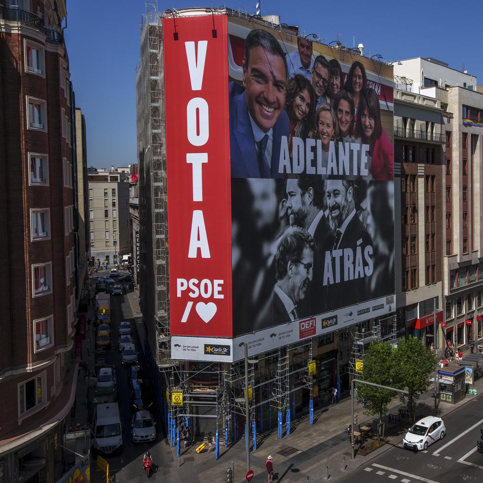 Un gigantesco cartel electoral  muestra al presidente del gobierno español y candidato del Partido Socialista, Pedro Sánchez, arriba, y al líder del conservador Partido Popular, Albert Núñez Feijóo, y del grupo de ultraderecha Vox, Santiago Abascal, en un edificio de la Gran Vía de Madrid, España.