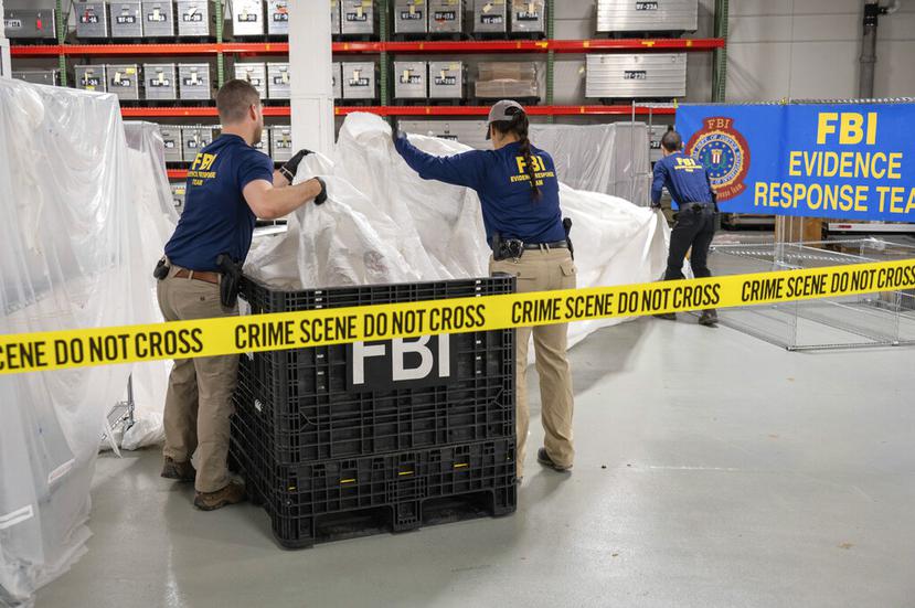 En esta imagen facilitada por el FBI, agentes asignados a un equipo especial manipulan el jueves 9 de febrero de 2023, en el laboratorio de la agencia, los materiales recuperados de un globo chino supuestamente espía que fue derribado en aguas frente a la costa de Carolina del Sur.