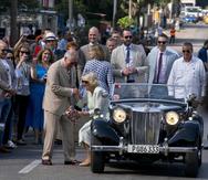 El príncipe Carlos ayuda a su esposa Camila a bajarse de un automóvil MG-TD de 1953.  (AP / Ramón Espinosa)