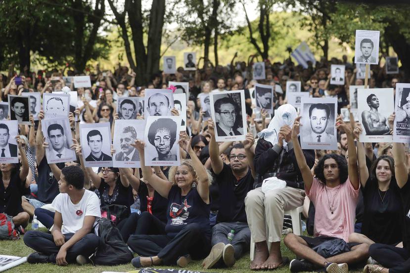Manifestantes muestras fotografías de personas que fueron asesinadas durante la última dictadura brasileña, en una protesta en Sao Paulo, Brasil. (AP / Andre Penner)