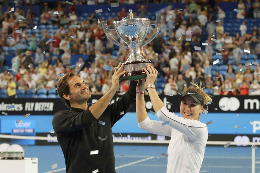 Los suizos Roger Federer y Belinda Bencic sostienen el trofeo de la Copa Hopman.